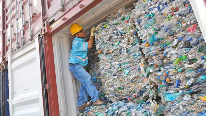 An officer stands inside a container full with plastic waste at Tanjung Priok port in Jakarta, Indonesia, September 18, 2019